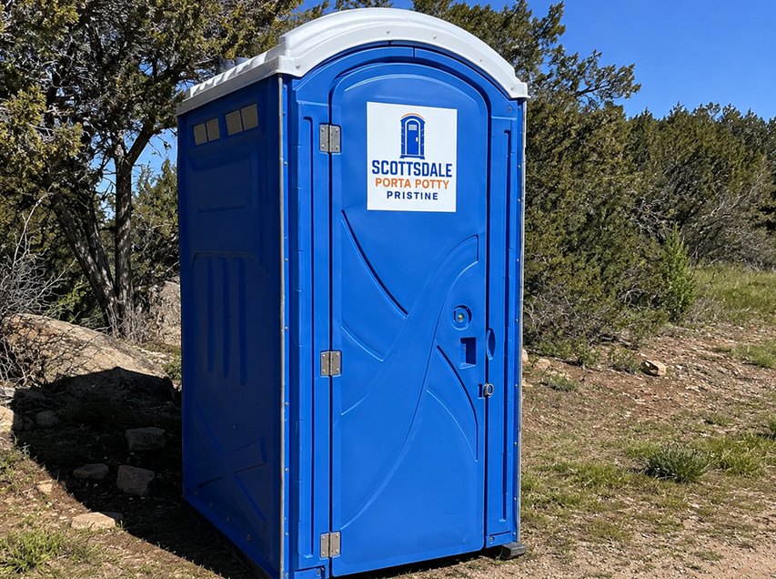 Blue construction porta potty rental placed on a desert building site